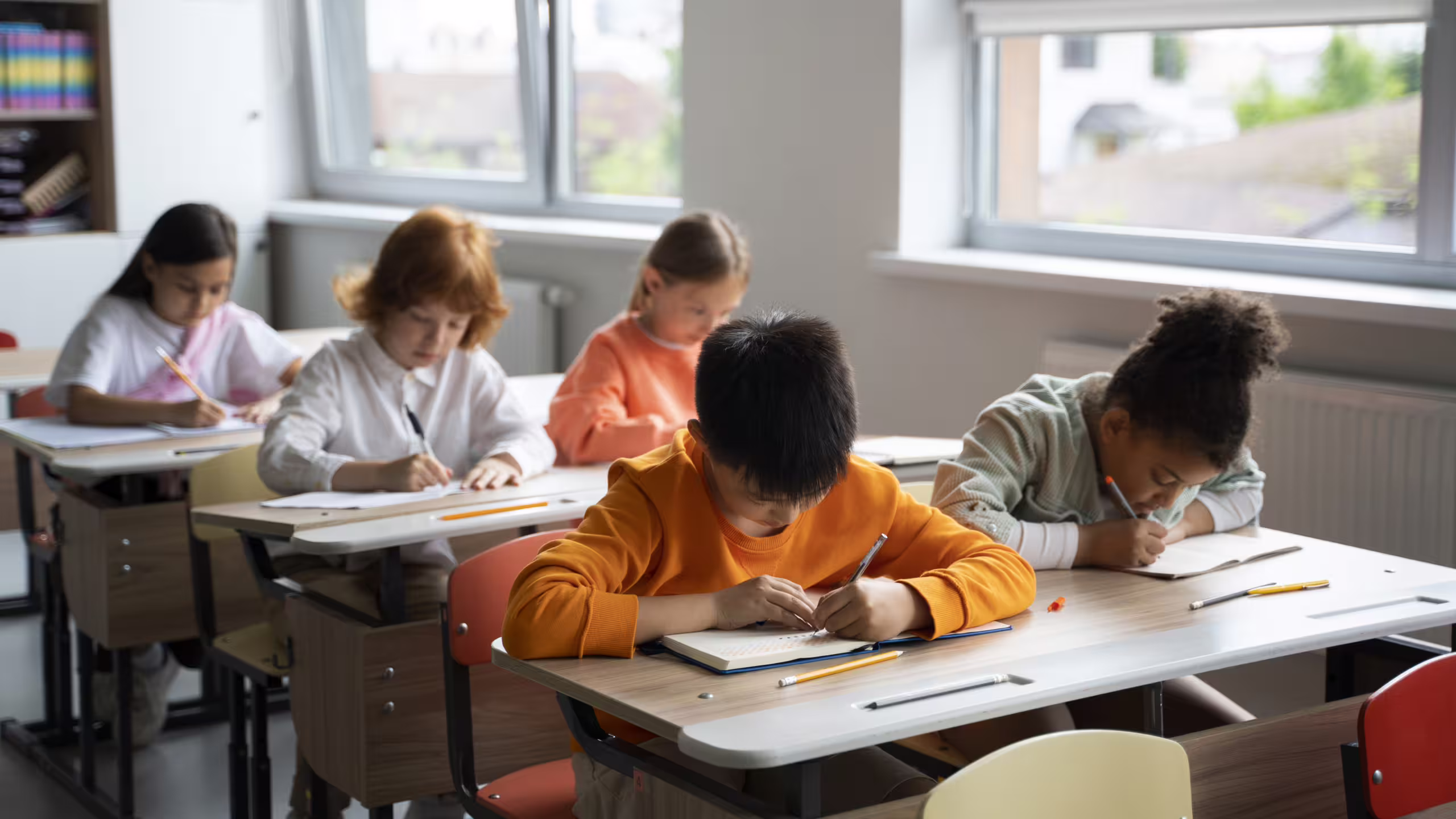 Kinder schreiben im Klassenzimmer.
